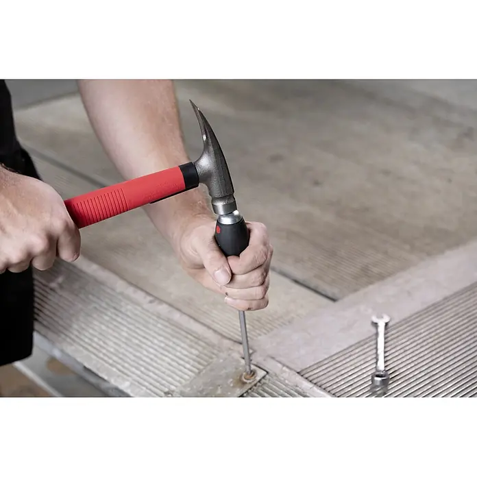 Wiha Schraubendreher-Set SoftFinish mit Stahlkappe - 6 -tlg. - Ein Mann benutzt einen Hammer-Schraubendreher mit rotem Griff, um an einer Metalloberfläche zu arbeiten. Werkzeug im Fokus.