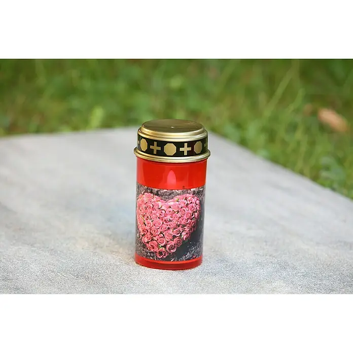 LED-Grablampe Tumba - Ø x H: 7 x 13 cm, Rot - Eine rote Grabkerze mit einem Herz aus Rosenmotiv, stehend auf einem grauen Stein, geeignet für stille Gedenkmomente auf dem Friedhof.