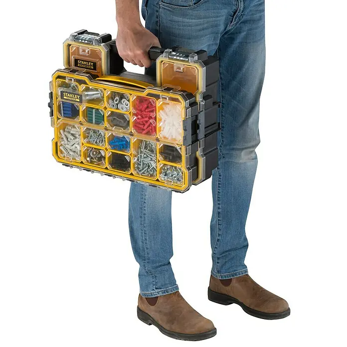 Stanley FatMax Kleinteilekoffer - Anzahl Fächer: 14 Stk. - Eine Person hält einen gelben Stanley Fatmax Organizer, der mit Schrauben und Nägeln gefüllt ist.