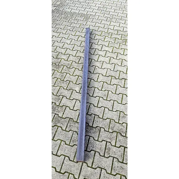 Jabo-Design Zaunpfosten Mitte - 6 x 240 cm - Ein langes, rechteckiges Metallstück liegt auf einem Pflasterweg und bietet vielseitige Anwendungsmöglichkeiten.