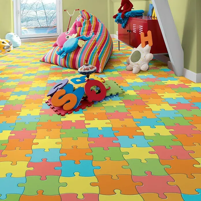 Tarkett Moqueta a metros Rompecabezas - Ancho: 2 m, Poliamida, Multicolor - Habitación infantil colorida con una alfombra de puzzle de colores que cubre el suelo, creando un espacio de juego.