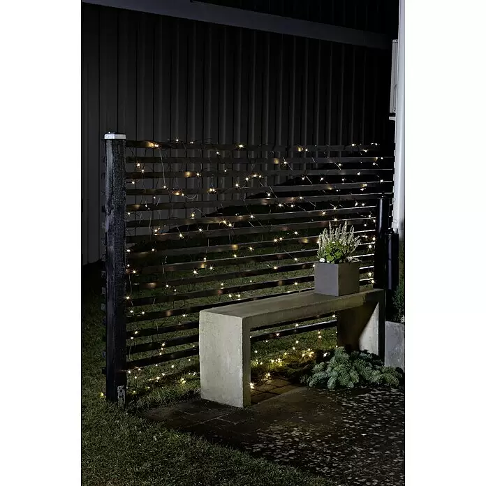 Konstsmide LED-Lichterkette - Innen, Lichtfarbe: Bernstein, Anzahl Leuchtmittel: 80 Stk. - Warmweiße LED-Lichterkette mit schwarzem Kabel beleuchtet einen Gartenspalierzaun und schafft ein gemütliches Ambiente im Freien.