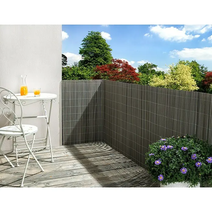 Sichtschutzmatte Comfort - 300 x 90 cm, Kunststoff, Grau - Eine stilvolle, graue Sichtschutzwand aus Bambus auf einem sonnigen Balkon mit Tisch und Stuhl. Ideal für Privatsphäre und als Dekoration.