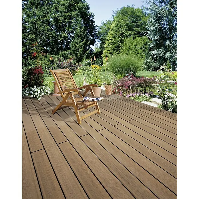 b!design WPC-Terrassendiele Ipe - 300 x 13,8 x 2,25 cm, Ipe - Einladende Terrasse mit hellbraunen Dielen und einem Holzliegestuhl, umgeben von üppigem Grün. Ideal zum Entspannen im Freien.