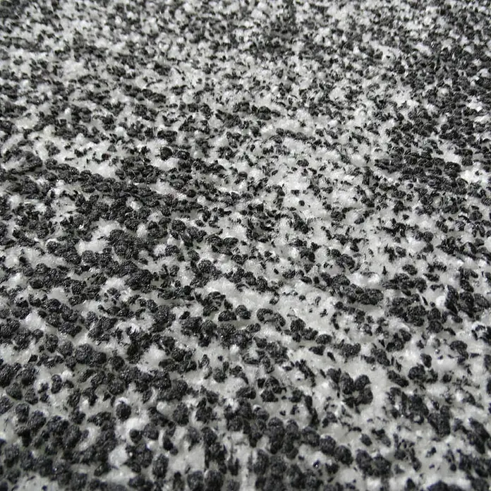 Kayoom Kurzflorteppich Etna - Anthrazit, 230 x 160 cm, 100 % Mikropolyester - Nahaufnahme eines Teppichs mit einem Muster aus kleinen schwarzen Punkten auf einem weißen Hintergrund.