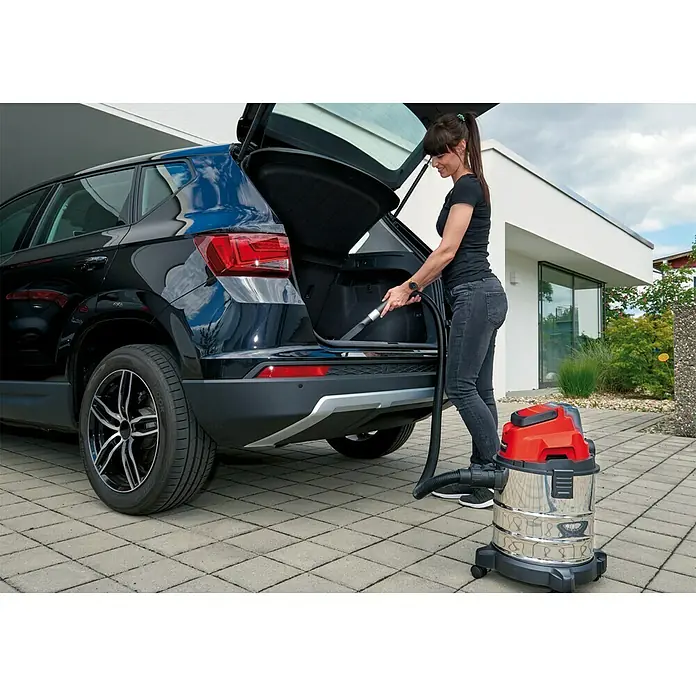 Einhell Power X-Change 18V Akku-Nass-Trockensauger TC-VC 18/20 Li-Solo - 18 V, Ohne Akku, Behältervolumen: 20 l - Frau saugt das Auto mit einem roten und silbernen Einhell Nass-Trockensauger. Er eignet sich perfekt für die Autoinnenreinigung.