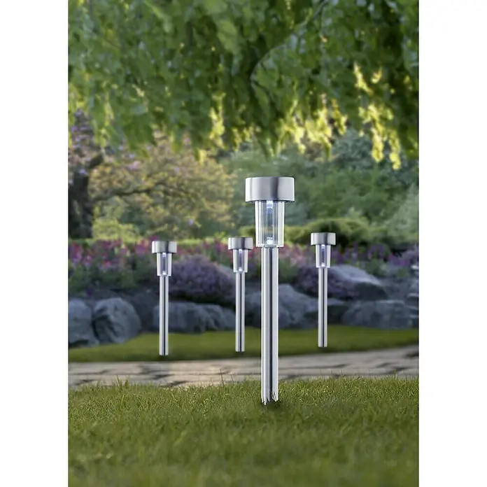 Starlux Estaca solar - 0,06 W, Plata, IP44, 4 lm - Las luces solares iluminan un sendero verde en el jardín, proporcionando un ambiente exterior suave y acogedor.