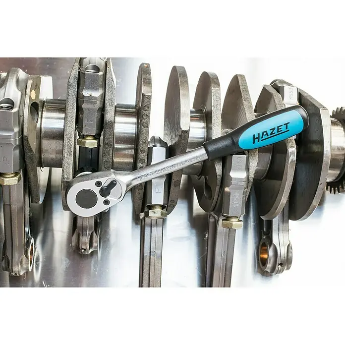 Hazet Umschaltknarre 8816P - 199 mm, ⅜″ Vierkant - Hazet Ratsche im Einsatz an einer Kurbelwelle. Das Werkzeug in Silber und Blau erleichtert die Arbeit an Motoren.