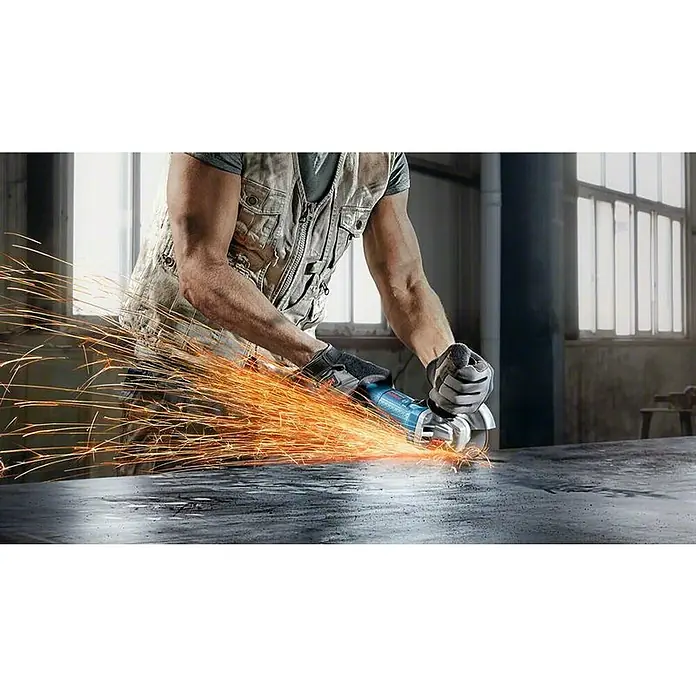 Bosch Professional Amoladora angular eléctrica GWS 880 - 900 W, Diámetro disco: 125 mm, Número de revoluciones de marcha en vacío: 11.000 r.p.m. - Un trabajador de la construcción usa una amoladora angular sobre una superficie metálica, saltando chispas. La herramienta es de Bosch, marca popular.