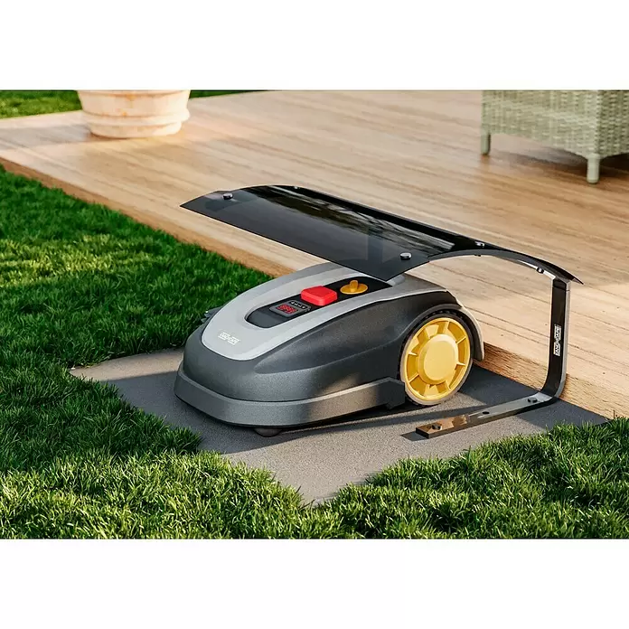 Landxcape Robot cortacésped LX838i - 800 m², Ancho de corte: 18 cm, Navegación por inducción, Cable de antena - Cortacésped robótico gris y negro con ruedas amarillas, cargando bajo una cubierta negra en una base gris junto a césped y tarima de madera.