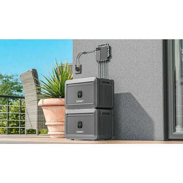 Growatt Batteriespeicher NOAH 2000 - 0% MwSt. gem. § 12 Abs. 3 UStG - Nennleistung: 2.000 W - Zwei Growatt-Batteriespeicher sind übereinander gestapelt, mit einem Verteilerkasten an der Wand und einem Topf mit Pflanzen daneben.
