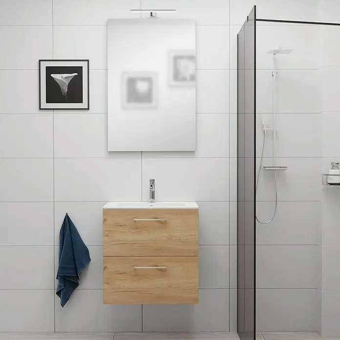Camargue Espacio Badmöbel-Set E55 - 60 cm, Doce - Ein Badezimmer-Waschtisch mit zwei Schubladen und einem Spiegel darüber, beleuchtet mit einer Lampe, neben einer Duschkabine.