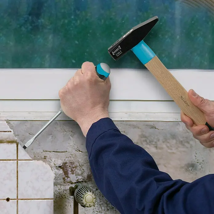 Hazet Schraubendreher-Set 810U-1 - 5 -tlg., Schlagkappe - Ein Hammer und ein Schraubendreher werden verwendet, um etwas zu bearbeiten. Der Hammer hat einen Holzgriff und der Schraubendreher einen blauen Griff.