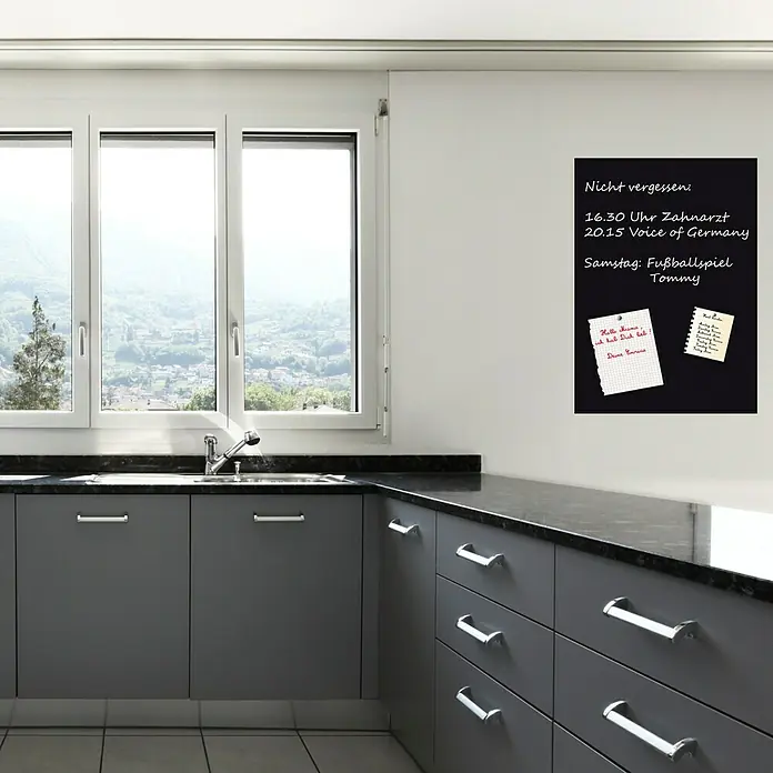 Magnetische Tafelfolie - Schwarz, 70 x 50 cm, Inkl. 3 Magnete und 3 Stück Kreide - Das Foto zeigt eine schwarze Memoboard-Wandtafel mit Notizen in einer modernen Küche, ideal für Erinnerungen und Nachrichten.