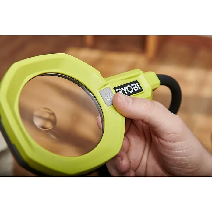 Ryobi ONE+ Akku-Lupenleuchte RML18-0 - 18 V, Ohne Akku - Nahaufnahme einer Ryobi Arbeitsleuchte in Gelbgrün, die von einer Hand bedient wird.