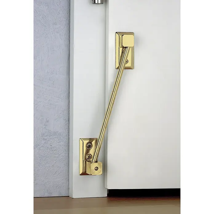 Burg-Wächter Elevador de puertas TH 68 - Altura de elevación: 9 mm - 16 mm, Baño de latón - Primer plano de un soporte de puerta dorado, montado en una puerta y marco blancos, que combina funcionalidad con un diseño elegante.