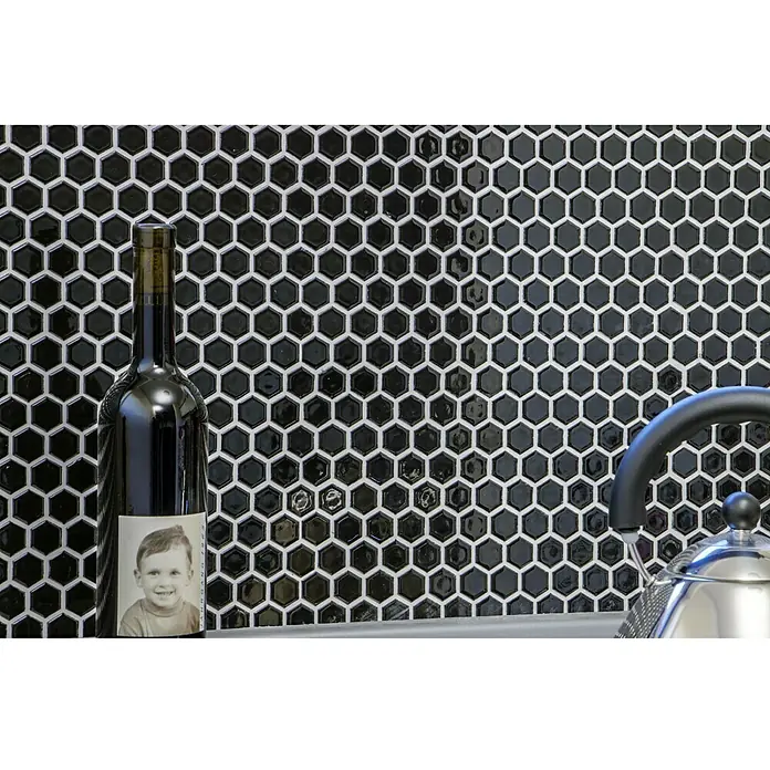 Mosaikfliese Hexagon Uni HX 060 - 26 x 30 cm, Schwarz, Glänzend - Nahaufnahme eines Weinregals mit schwarzen, sechseckigen Fliesen als Hintergrund, eine stilvolle und moderne Dekoration.