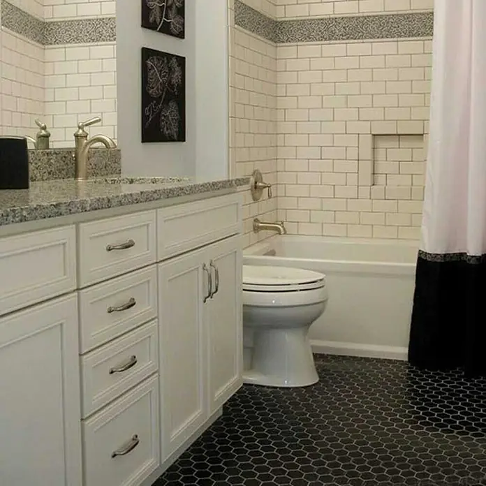 Mosaikfliese Hexagon Uni HX 095 - 32,5 x 28,1 cm, Schwarz, Matt - Das Badezimmer verfügt über einen weißen Waschtisch, eine Toilette und dunkle sechseckige Fliesen.