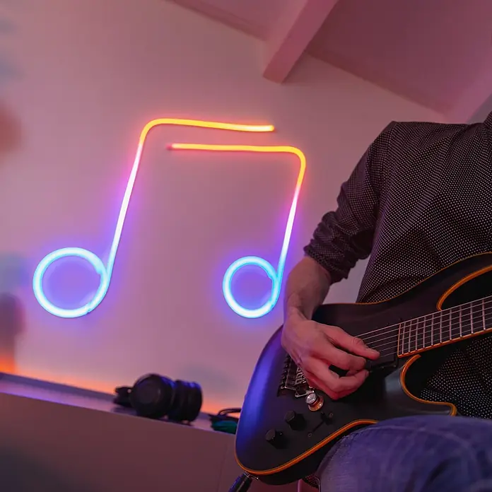 Twinkly LED-Lichtschlauch Flex - Länge: 2 m, Lichtfarbe: RGB, 15 W - Gitarrist spielt E-Gitarre vor einer leuchtenden Note. Die perfekte Atmosphäre für Musikliebhaber und kreative Köpfe.