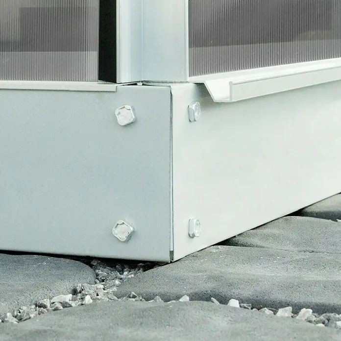 Vitavia Gewächshaus Venus 5000 Plus - Außenmaß inkl. Dachüberstand (B x T): 195 x 257 cm, 4 mm, Aluminium - Nahaufnahme eines weißen Gartenbausatzes mit Schrauben und einer klaren Abdeckung, der auf grauen Steinen steht.