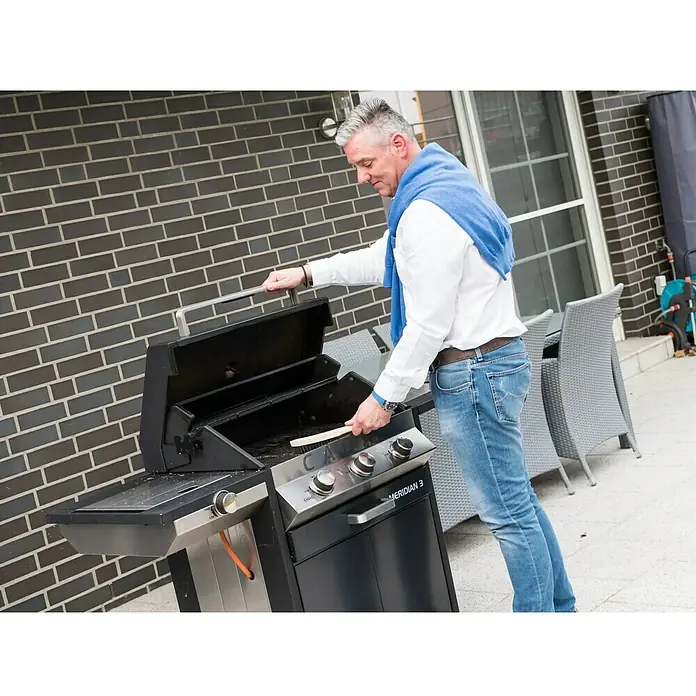 Hazet Drahtbürste 2130 - Anzahl Reihen: 4 Stk. - Ein Mann reinigt einen Meridian 3 Gasgrill im Freien, bereit für das nächste Barbecue mit Freunden oder Familie.