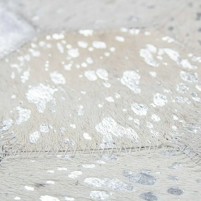 Kayoom Lederteppich Dazzle 200Grau/Silber, 170 x 120 cm, 100 % Leder - Nahaufnahme eines luxuriösen Kuhfellteppichs mit silbernen Akzenten. Das Muster und die Textur des Teppichs sind gut sichtbar.