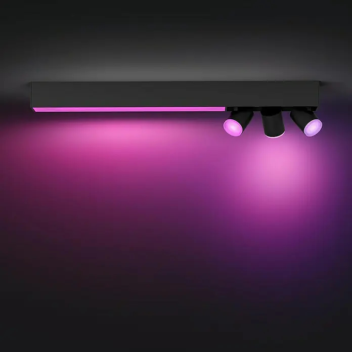 Philips Hue LED-Deckenstrahler White & Color Ambiance Centris - 22,4 W, L x B x H: 8,5 x 78,2 x 12,7 cm, Schwarz, RGBW, 4 Stk. - Das Bild zeigt eine moderne, schwarze Deckenleuchte mit drei Strahlern, die ein violettes Licht abstrahlen. Die Leuchte ist stilvoll und beleuchtet den Raum effektvoll.