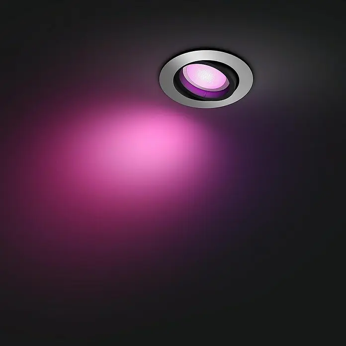 Philips Hue LED-Einbauspot White & Color Ambiance Centura - RGBW, Durchmesser: 9 cm, Farbe Gehäuse: Alu - Ein runder Deckenstrahler mit silbernem Rand und einem leuchtend rosa Lichtkegel, der eine moderne und stimmungsvolle Beleuchtung erzeugt.