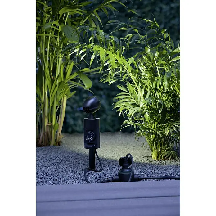 Ritter Leuchten LED-Gartenspot - 3 W, Höhe: 400 mm, Erdspieß, Kunststoff - Nahaufnahme einer smarten Gartenlampe mit Dimmerfunktion, eingebettet in eine grüne Pflanzenkulisse.
