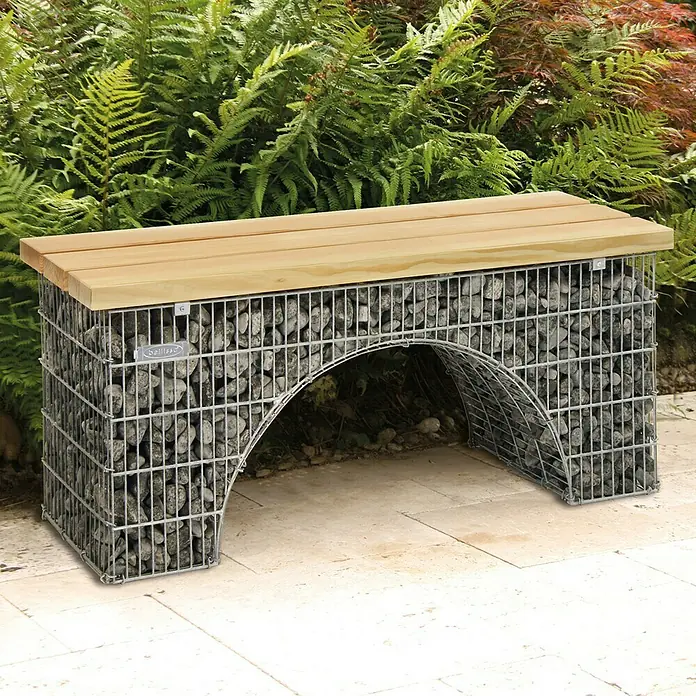 Bellissa Gartenbank-Gabione Arco - L x B x H: 125 x 45 x 54 cm - Gartenbank mit Gabionenfuß und Holzplatte. Die Bank steht auf einer Terrasse vor grünen Pflanzen.