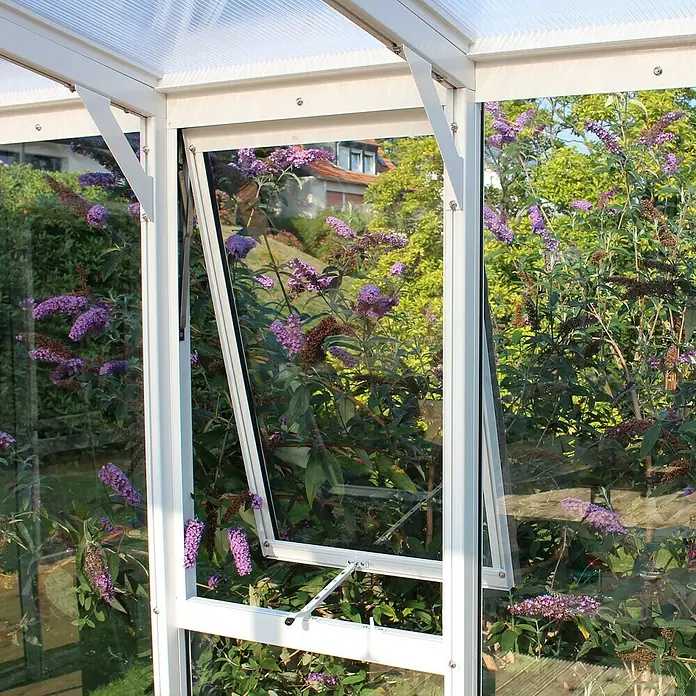 Vitavia Gewächshaus Helena 10200 Plus - Außenmaß inkl. Dachüberstand (B x T): 397 x 266 cm, 3 mm, Weiß - Nahaufnahme eines Gewächshausfensters mit Blick auf blühende Pflanzen. Das Fenster ist teilweise geöffnet und gibt den Blick auf die Gartenpracht frei.