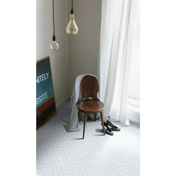 Beauflor PVC-Boden Meterware Hightex - 300 cm, Trentino, Weiß - Nahaufnahme eines stilvollen Raumes mit einem klassischen Holzstuhl, eleganten Schuhen und einem auffälligen, modernen Bodenmuster.
