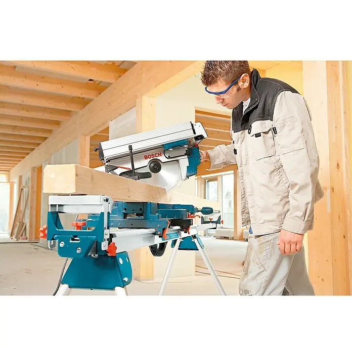 Bosch Professional Sierra ingletadora GTM 12 JL - Diámetro hoja de sierra: 305 mm - Una sierra ingletadora Bosch en acción, cortando con precisión una pieza de madera, con un artesano operándola.