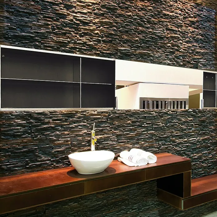 Revestimiento de piedra Galicia - Pizarra, Cantidad total: 4 pzs. - Elegante interior de baño con un lavabo moderno sobre una repisa de madera contra una pared de piedra texturizada. Armarios negros y espejo arriba.