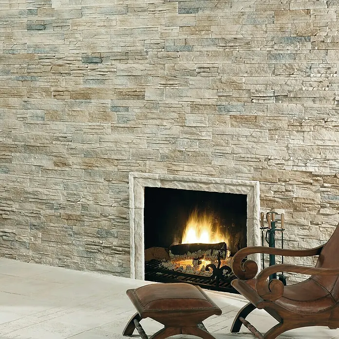 Revestimiento de piedra Petra Cuarzo - Cantidad total: 4 pzs., Cuarzo - Acogedora sala de estar con chimenea de piedra y sillón a juego para un toque cálido y elegante.