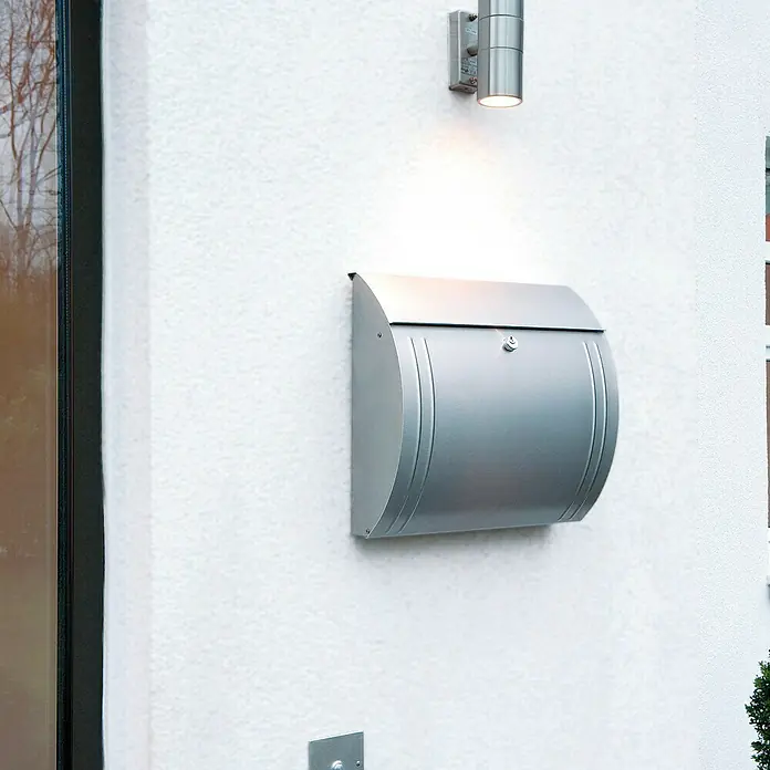 Tesa Powerbond Cinta de doble cara Outdoor - 19 mm x 1,5 m, Negro - Buzón moderno de acero inoxidable con cerradura integrada y lámpara de superficie en una pared blanca.