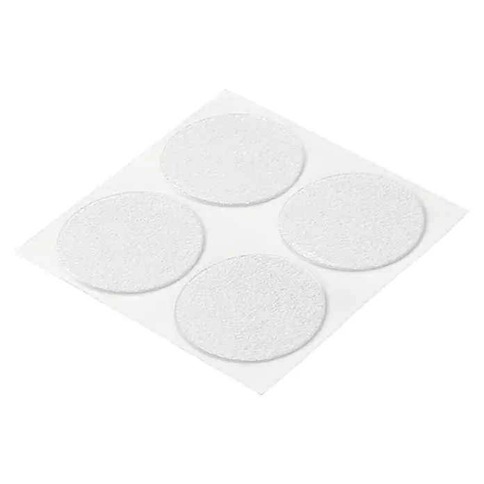 Inofix Adhesivo antideslizante 5301-0 - Diámetro: 38 cm, Transparente, Pegado, 16 ud. - La imagen muestra deslizadores de muebles unidos a un papel soporte. Protegen los suelos de arañazos y facilitan el movimiento de los muebles.