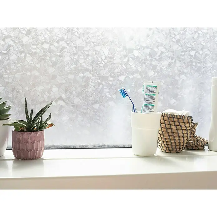 D-c-fix Static Glasfolie Splinter - 150 x 90 cm, Transluzent, Statisch haftend - Fensterfolie mit geometrischem Muster sorgt für Privatsphäre. Im Badezimmer stehen eine Pflanze, eine Zahnbürste und eine Tube Zahnpasta.