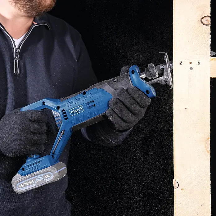 Scheppach IXES 20V Akku-Säbelsäge C-RS100-X - 20 V, Hublänge: 20 mm - Nahaufnahme einer Scheppach Akku-Säbelsäge beim Schneiden von Holz, ideal für Renovierungs- und Abbrucharbeiten.