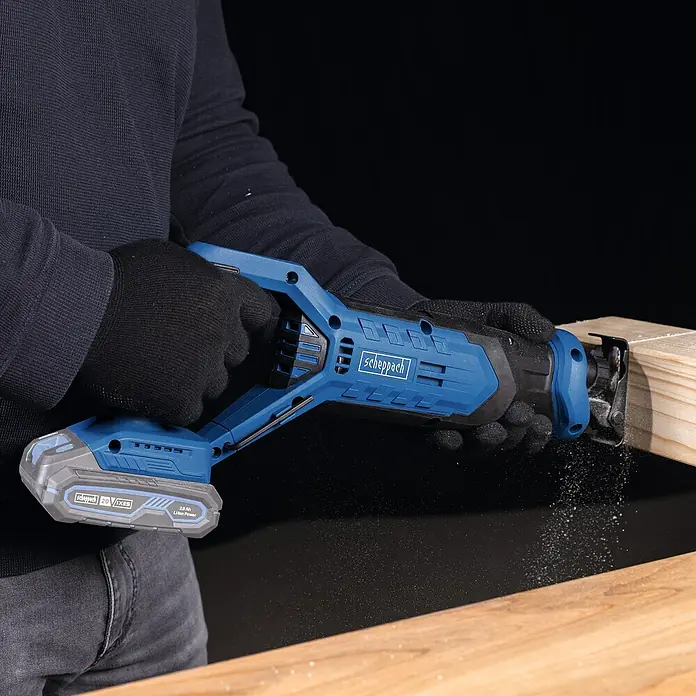 Scheppach IXES 20V Akku-Säbelsäge C-RS100-X - 20 V, Hublänge: 20 mm - Nahaufnahme einer Scheppach Akku-Säbelsäge beim Sägen eines Holzstücks, ideal für Heimwerkerprojekte.
