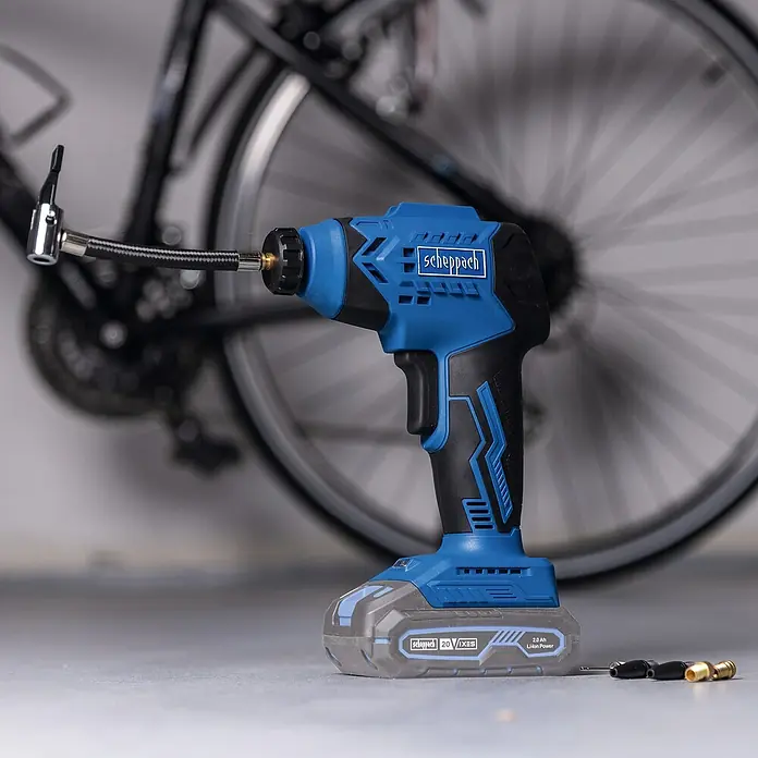 Scheppach IXES 20V Akku-Luftpumpe C-AC20-X - Max. Druck: 7 bar, Autostopp - Scheppach Akku-Luftpumpe mit Fahrrad im Hintergrund. Ideal für unterwegs, um Reifen schnell aufzupumpen. Kompaktes Design.