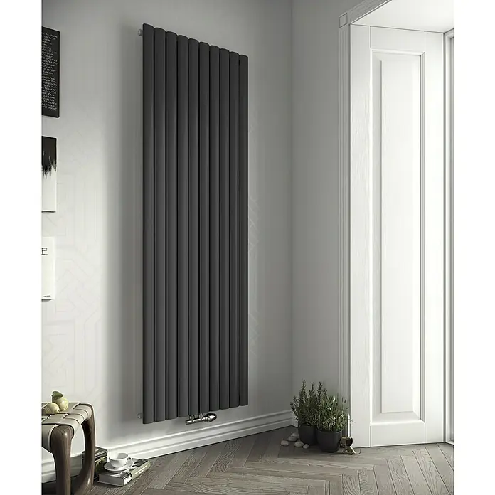 Ximax Raumheizkörper Fortuna - B x H: 236 x 1.800 mm, Wärmeleistung bei Vorlauftemperatur von 75 °C (D: 50): 494 W, Anthrazit - Ein moderner, anthrazitfarbener Heizkörper mit vertikalen Paneelen, der an einer weißen Wand in der Nähe einer weißen Tür installiert ist.