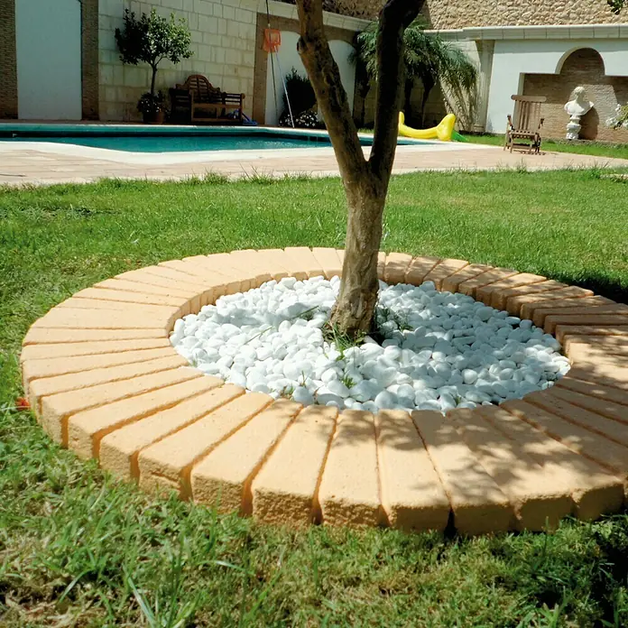 Paso para árboles Tova - Beige - Idea de diseño de jardín con un parterre circular hecho con adoquines alrededor de un árbol, lleno de piedras blancas.