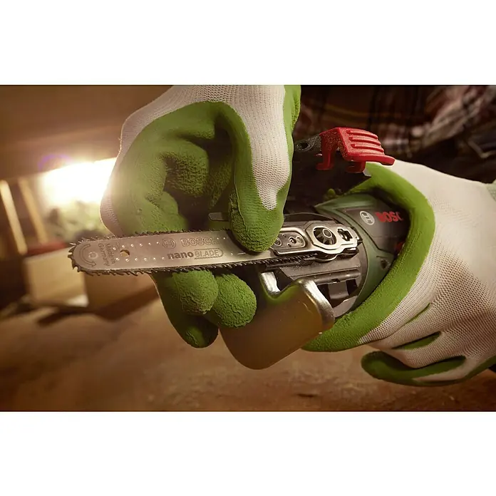 Bosch Power for All 18V NanoBlade-Säge AdvancedCut 18Leerlaufdrehzahl: 7.000 U/min, 18 V, Ohne Akku - Nahaufnahme einer Hand mit Handschuh, die eine Bosch NanoBlade Säge hält, mit Fokus auf Präzision und innovative Schneidetechnologie.