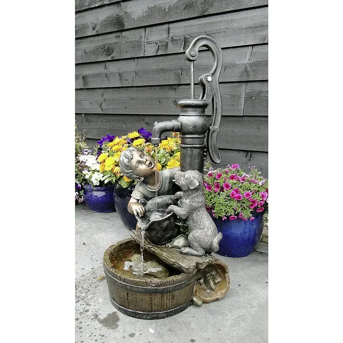 Ubbink AcquaArte Gartenbrunnen Regina - 38 x 40,5 x 77 cm, Kunststoff, Grau, Braun - Detailaufnahme eines dekorativen Gartenbrunnens mit einer Skulptur eines Jungen und eines Hundes, die Wasser aus einer Pumpe trinken.