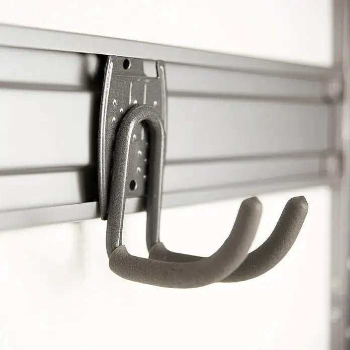 Phönix Regal-Set Staxx Garage - L x B x H: 62 x 65 x 223,6 cm, Eiche/Silber - Nahaufnahme eines grauen Gerätehalters, der an einer grauen Lamellenwand befestigt ist, ideal für Garagenorganisation und Werkzeugaufbewahrung.