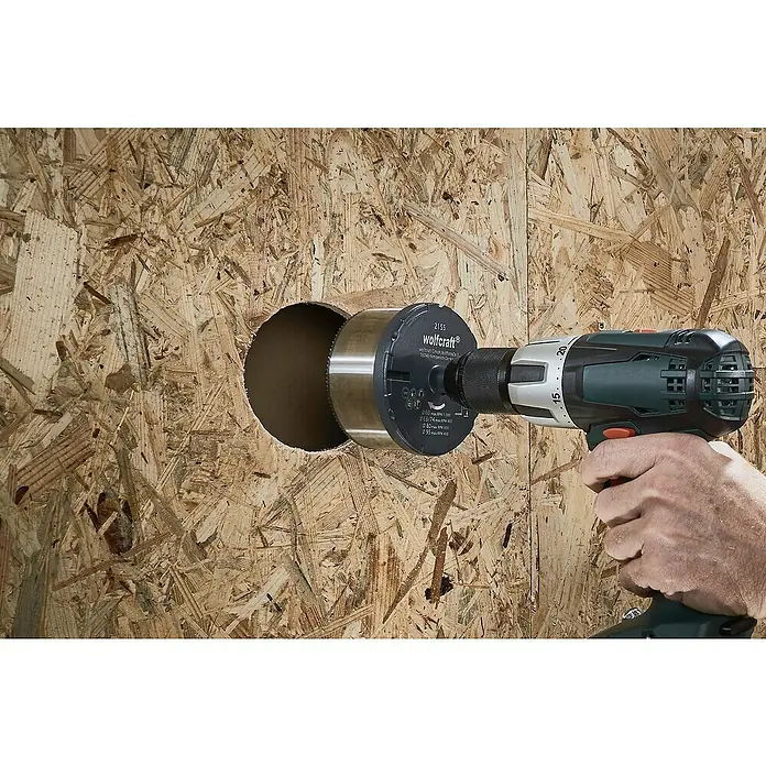 Wolfcraft Mehrkranzlochsäge - 3 -tlg., Schnitttiefe: 33 mm - Bohren eines Lochs in eine OSB-Platte mit einer Wolfcraft Lochsäge, die an einer Bohrmaschine befestigt ist.
