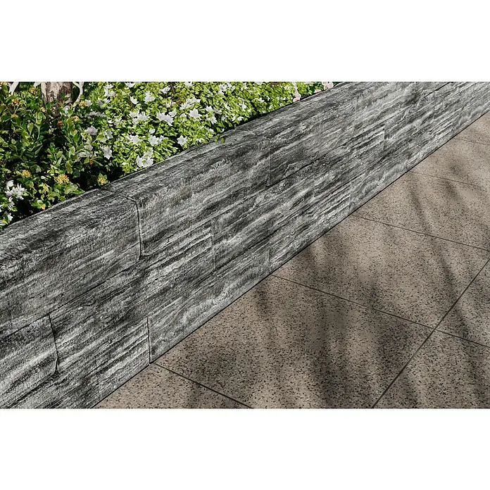 Christoph Mauerstein Rustikalblock - 50 x 12,5 x 14 cm, Anthrazit/Weiß, Beton - Die elegante graue Steinmauer mit charmanten weißen Blüten sorgt für eine attraktive Gartengestaltung und eine natürliche Atmosphäre.