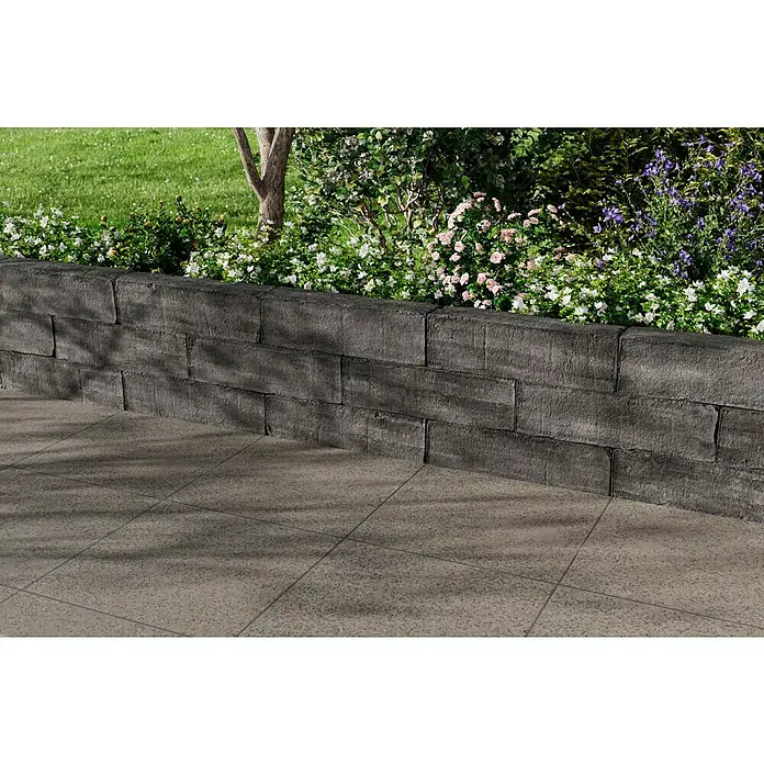 Christoph Mauerstein Rustikalblock - 50 x 12,5 x 14 cm, Kristall/Anthrazit, Beton - Hier ist eine attraktive Stützmauer aus grauen Steinen, die mit bunten Blumen bepflanzt ist und einen schönen Gartenbereich schafft.