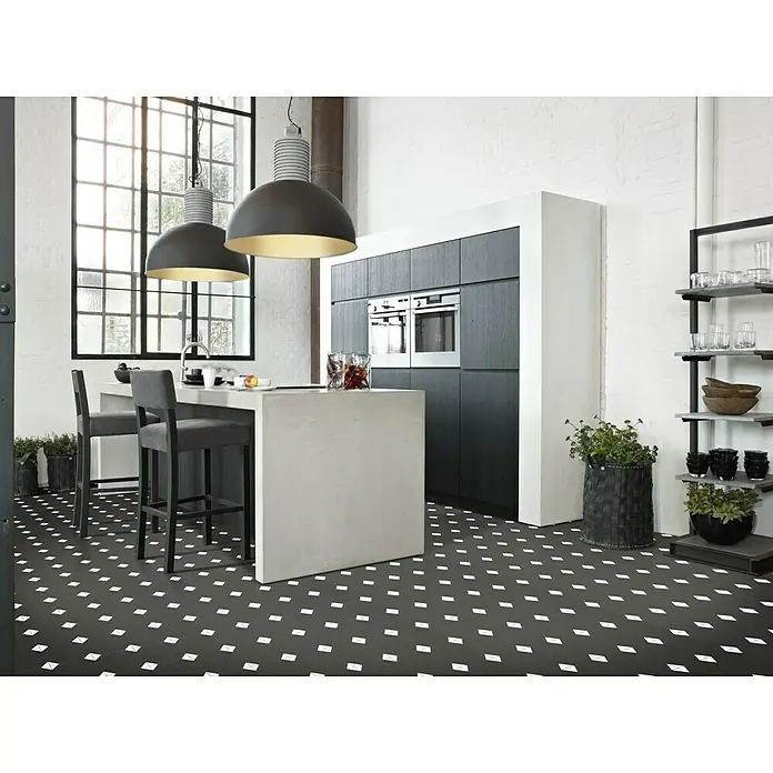 Beauflor PVC-Boden Meterware Tex-Style - 400 cm, Avondale, Schwarz/Grau - Moderne Küche mit dunklen Schränken, einer Kochinsel und auffälligem schwarz-weißem Bodenmuster. Zwei elegante Hängelampen beleuchten den Raum.